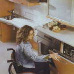 Kerekesszékben ülő hölgy kinyitja a mosogatógép ajtaját
